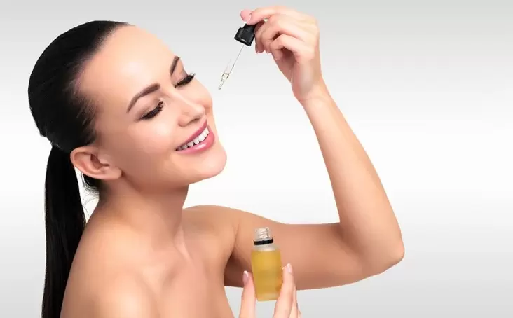 woman applying serum to the face